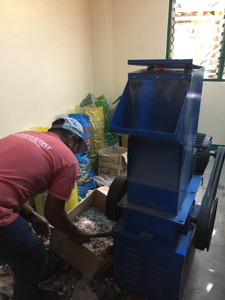 The school’s machine technician demonstrates how to use the plastic shredder.